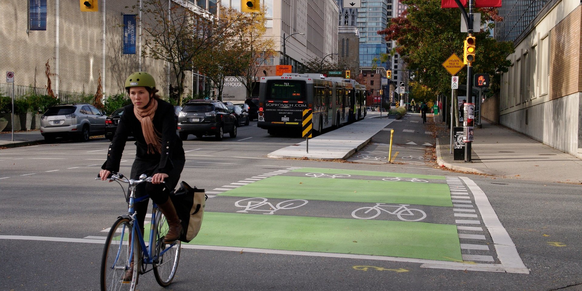 Eine Frau fährt auf einem Fahrrad in einer so genannten Protected Bike Lane