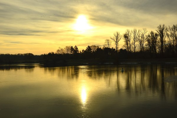 Flusslandschaft mit tiefstehender Sonne