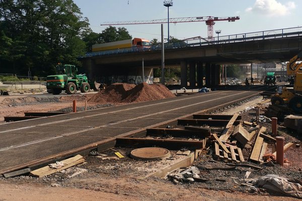 Farbbild einer Baustelle, im Hinrtergrund eine Brücke