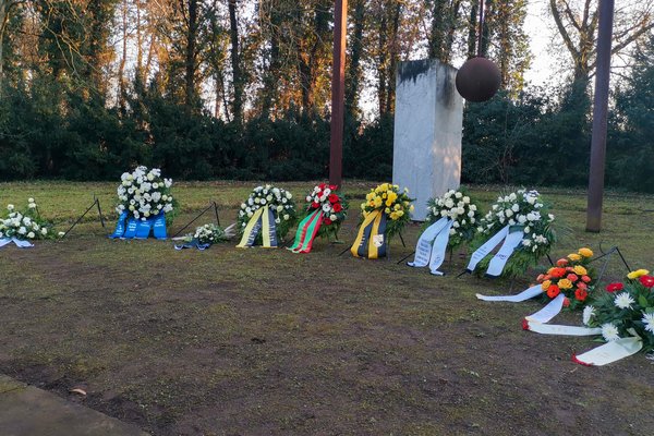 Kränze vor der symbolischen Glocke des Denkmals auf dem Westfriedhof