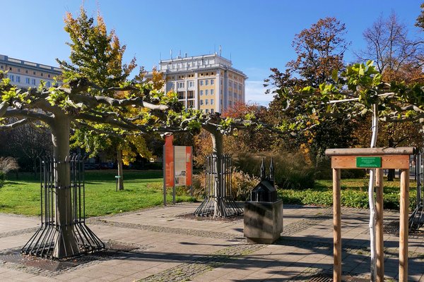 Blick auf eine kleine Parkanlage mit einem bronzedenkmal für eine Kirche